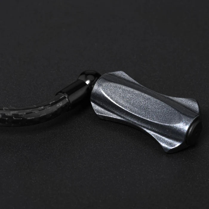 Eine Nahaufnahme des Gomexus CraftFin-35 Carbon Griffs für Stationärrollen - 35mm Carbon Kurbelarm mit 18mm Knauf und flexiblem, schwarz geflochtenem Kabel - ideal für Ultralight Angelrollen Fans, die stilvolle Haltbarkeit suchen.