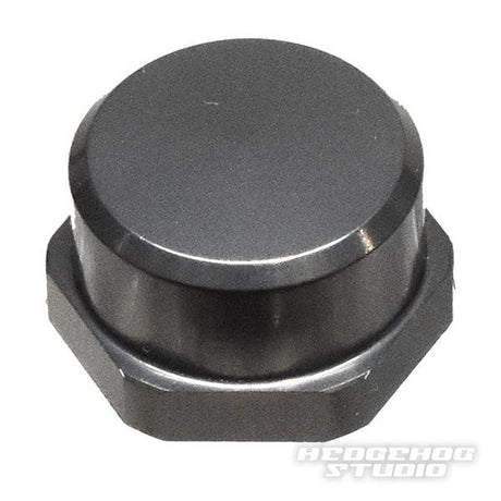 Eine Nahaufnahme der metallischen Hedgehog Studio Shimano Handle Locknut M7 zeigt ihre elegante, reflektierende Sechskantkappe mit glatter Oberseite. „HEDGEHOG STUDIO“ und „Handle Locknut“ sind in der unteren rechten Ecke zu sehen.