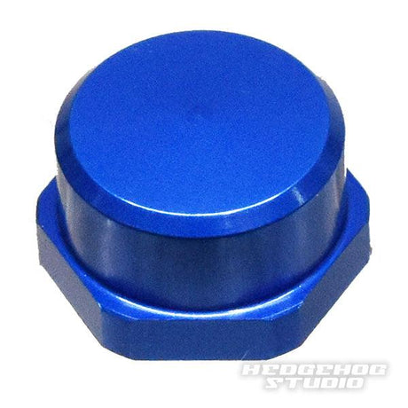 Auf weißem Grund ist eine metallisch blaue Sechskantkappe mit glatter, runder Oberseite abgebildet. Das Hedgehog Studio Logo ist schwach zu erkennen und weist darauf hin, dass es sich um die Shimano Handle Locknut M7 für originale Shimano Kurbeln von Hedgehog Studio handelt.