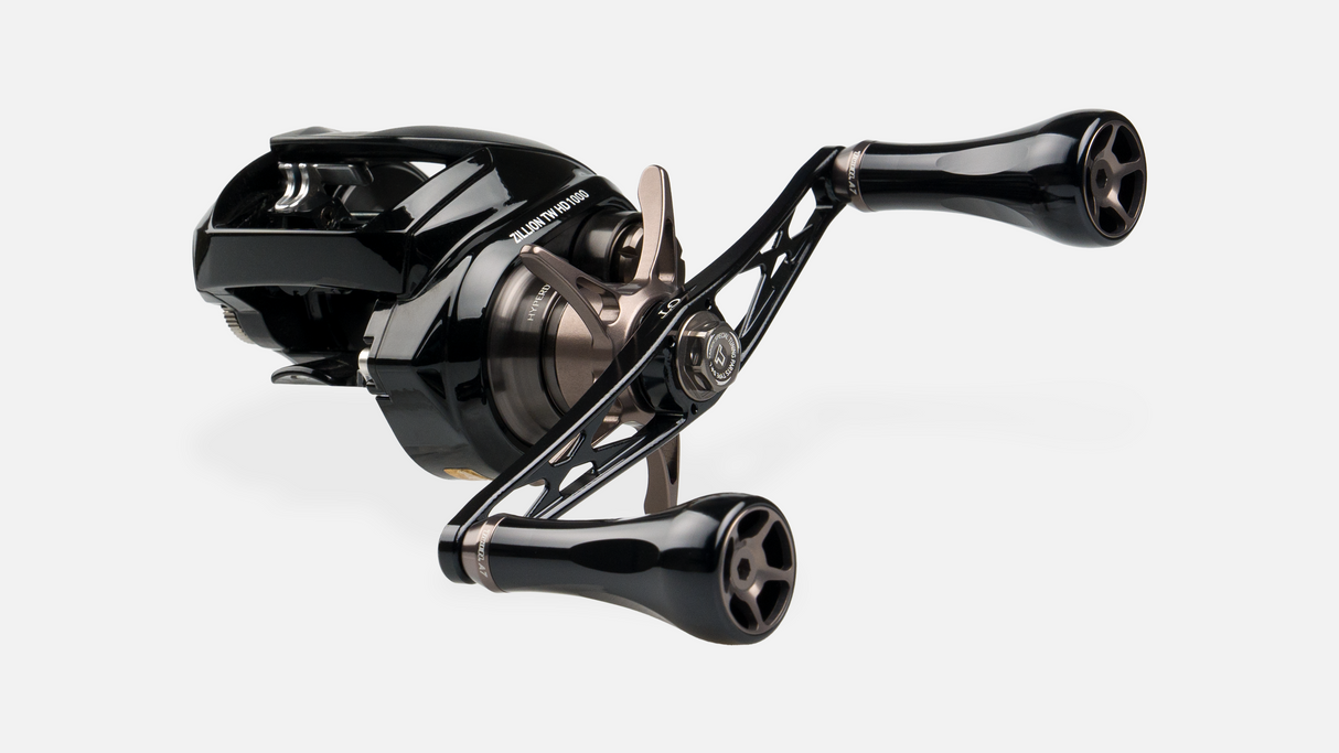 Der Taken GT106 Handle von Taken ist ein schwarzer Power Handle aus Duraluminium mit zwei groΓen A7 AluminiumknΓΆpfen fΓΌr Shimano & Daiwa, abgebildet auf einer schlanken kompakten Rolle vor einem schlichten weiΓen Hintergrund.