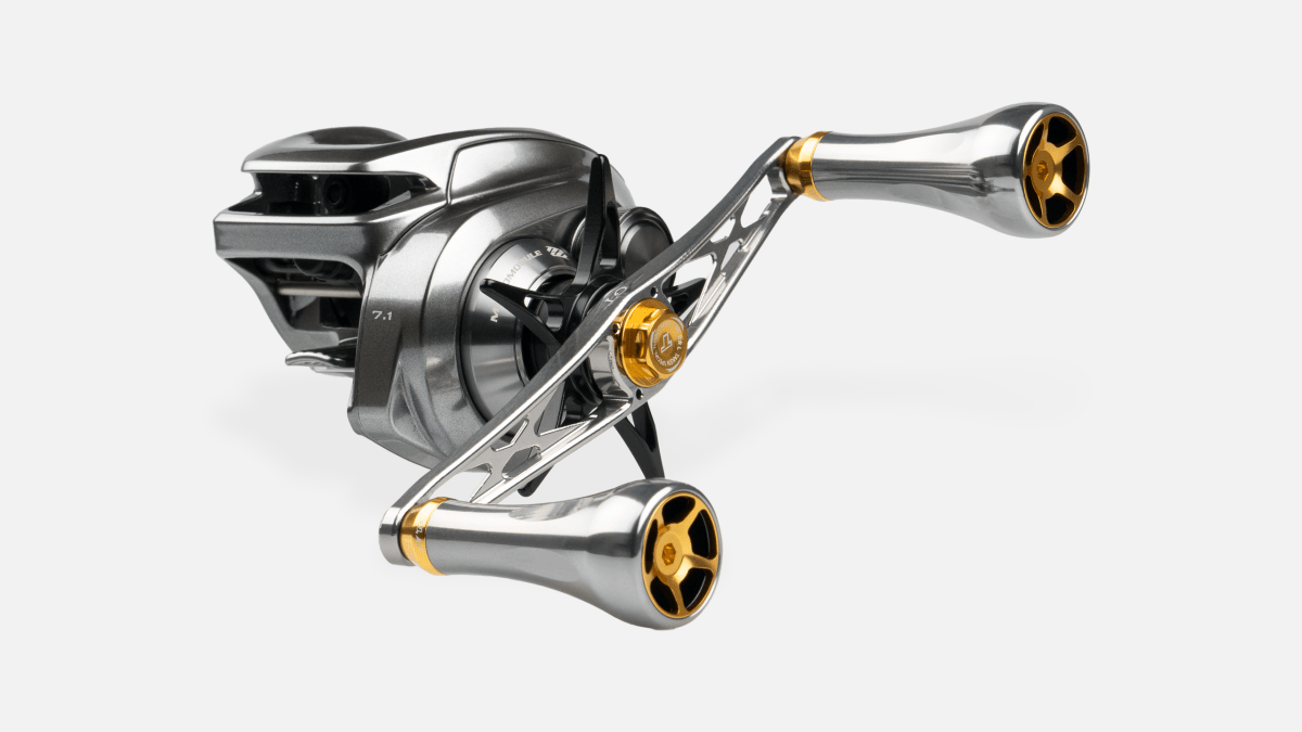Eine Nahaufnahme des Taken GT106 Griffs - ein Power-Griff von Taken aus Duraluminium mit A7-Knöpfen, entwickelt für Shimano- und Daiwa-Rollen, mit silbernen und goldenen Akzenten und einem modernen, stromlinienförmigen Look auf weißem Hintergrund.