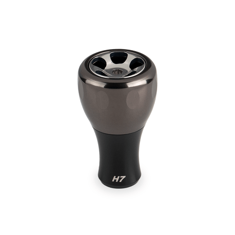 Ein Gunmetal Taken H7 Knob 40mm-Aluminium Tuning Knauf für Baitcaster & Stationärrollen (Shimano & Daiwa) von Taken steht aufrecht vor einem weißen Hintergrund, mit H7 beschriftet an der Basis.