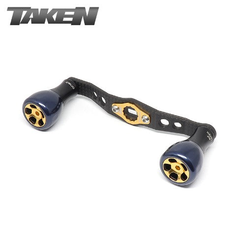 Der Taken H7 SS Crossover Carbon Griff 100 mm ist ein Carbongriff mit königsblauen H7 Aluminiumknöpfen, der für Shimano und Daiwa entwickelt wurde und das TAKEN Logo trägt.