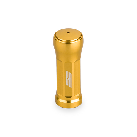 Der Taken SS Knob 35mm - Tuning Aluminium Knauf für Shimano & Daiwa Angelrollen von Taken ist ein goldfarbener zylindrischer Metallknauf mit vertikalen Rillen und einem weißen SS-Logo auf der Vorderseite, abgebildet auf einem weißen Hintergrund.