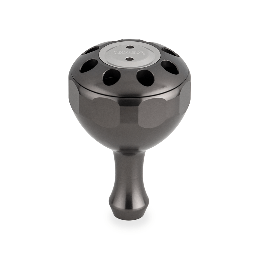 Der Taken X3 Knob 50mm ist ein kugelförmiger Power Tuning Knauf aus Rotguss für Shimano & Daiwa Hecht/Bigbait Rollen. Er verfügt über einen sechseckigen Schaft, kreisförmige Löcher auf der Oberseite und eine eingravierte runde Platte auf weißem Hintergrund.