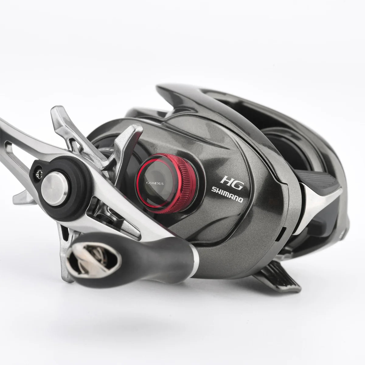 Eine Nahaufnahme einer Shimano Baitcaster HG-Rolle mit grauem Metallic-Finish, Metanium-Tuning und der Gomexus Aluminum Spool Tension Knob Cap (20/22/23 Metanium) in Rot sowie einem schwarz-silbernen Griff auf weißem Hintergrund.