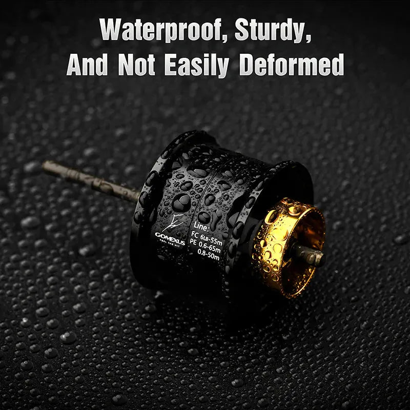 Eine schwarz-goldene Gomexus Aluminiumspule für die Daiwa Tatula TW 80 mit Wassertropfen liegt auf einer nassen, strukturierten Oberfläche. Der Text darüber lautet: Wasserdicht, robust und verformt sich nicht leicht. Marke: Gomexus.