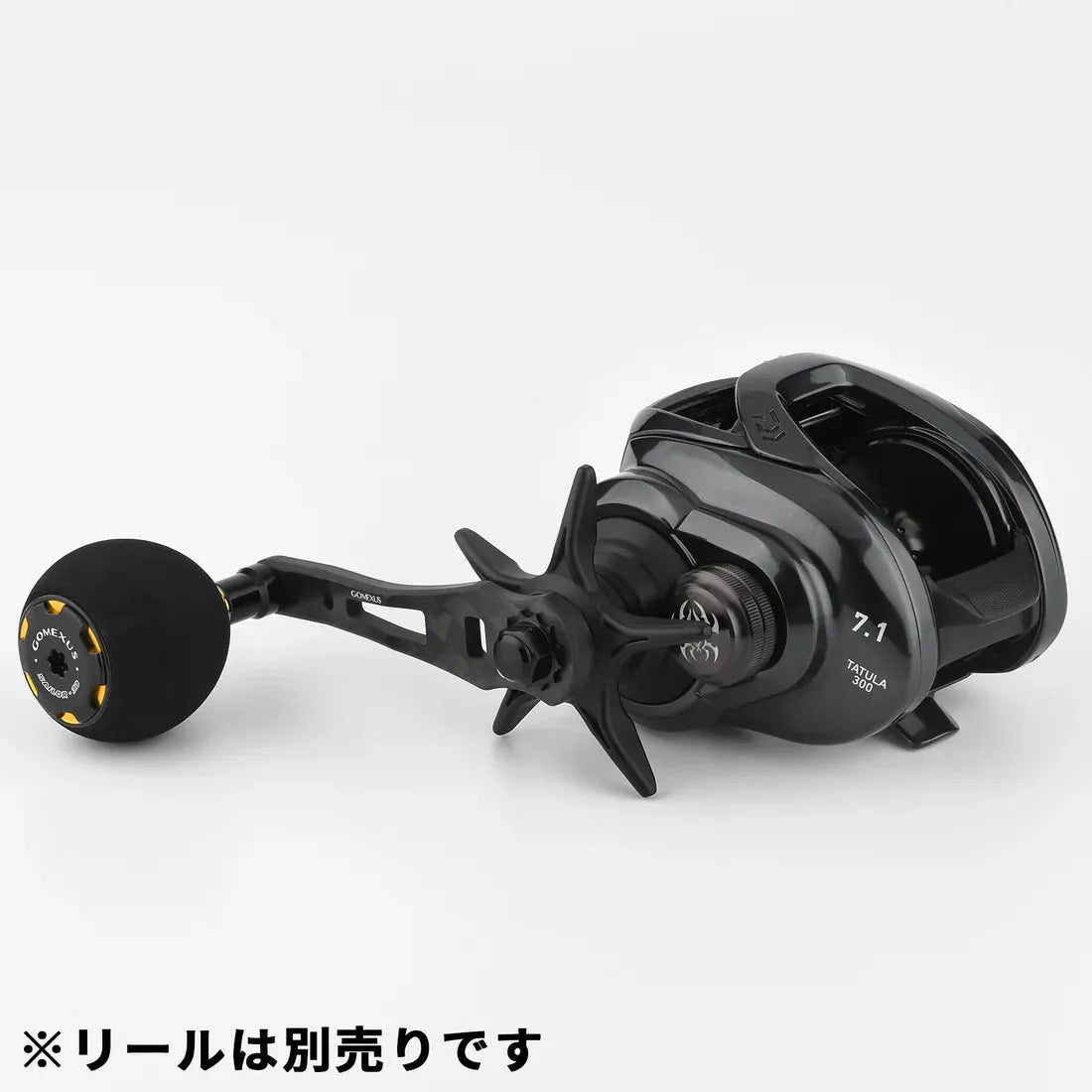 Ein schwarzer Gomexus Forged Carbon Handle 65–75 mm mit EVA Power Knob ist an einer Baitcasting-Rolle mit der Aufschrift „7.1“ und „T3A-LA 80PA“ sowie japanischem Text an der Unterseite befestigt.