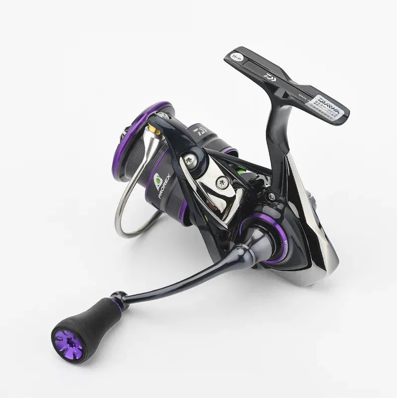 Eine schwarz-violette Angelrolle mit gebogenem Griff, dem Gomexus P20 mm TPE-Knauf und metallischen Akzenten sowie einer sichtbaren Spule. Die Rolle ist auf einem schlichten weißen Hintergrund abgebildet. Marke: Gomexus.