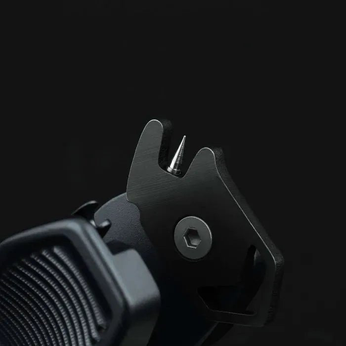 Nahaufnahme des Gomexus SharkBite Schnurknipser Combo von Gomexus, ein schwarzes Metallwerkzeug mit einem spitzen Dorn und einem Sechskantbolzen vor einem dunklen Hintergrund.