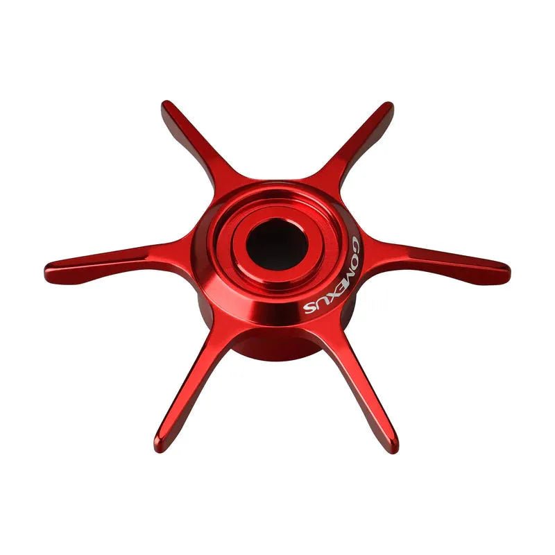 Eine rote Gomexus Sternbremse 65 mm Aluminium mit sechs Speichen und einem zentralen Loch, von oben betrachtet. Eine Speiche trägt das GOMEXUS-Logo. Das schlanke Design ist kompatibel mit Daiwa Baitcastrolle Stardrag-Systemen.