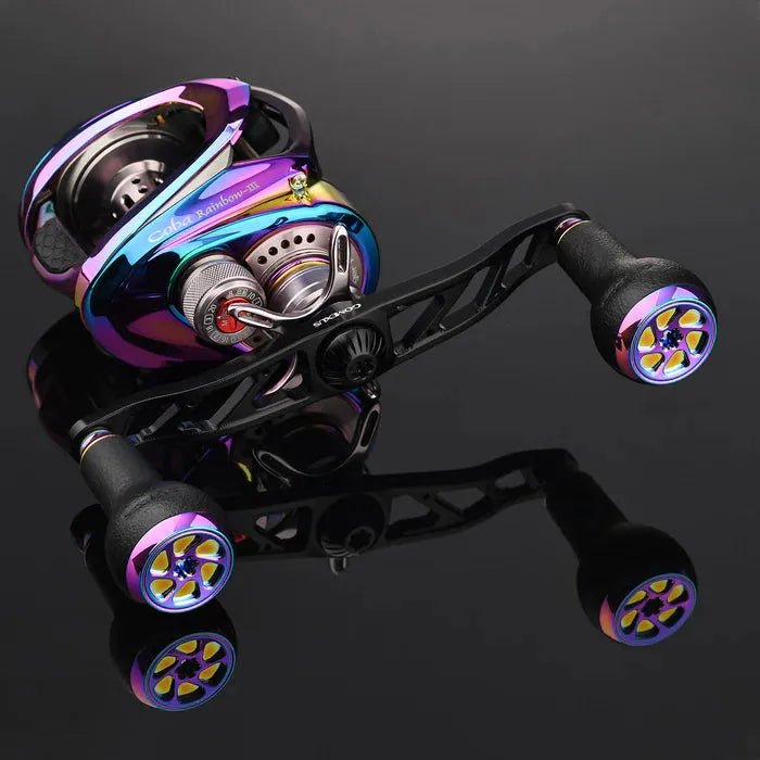 Abgebildet ist eine Baitcastingrolle mit Gomexus Super Duralumin 120-mm-Griff und 27-mm-Aurora-TPE-Knöpfen (7 x 4 mm) in metallischem Mehrfarbendesign und glatten Griffen vor einer glänzend schwarzen reflektierenden Oberfläche.