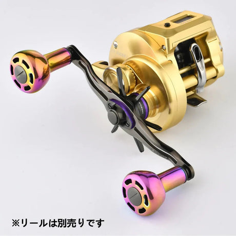Eine Nahaufnahme eines metallischen Rollengriffs mit dem Gomexus Titanium Power Knob 30 mm TA30 in Regenbogenfarben, befestigt an einer goldenen Rolle. Der japanische Text lautet: ※リールは別売りです (Die Rolle ist separat erhältlich). Marke: Gomexus.
