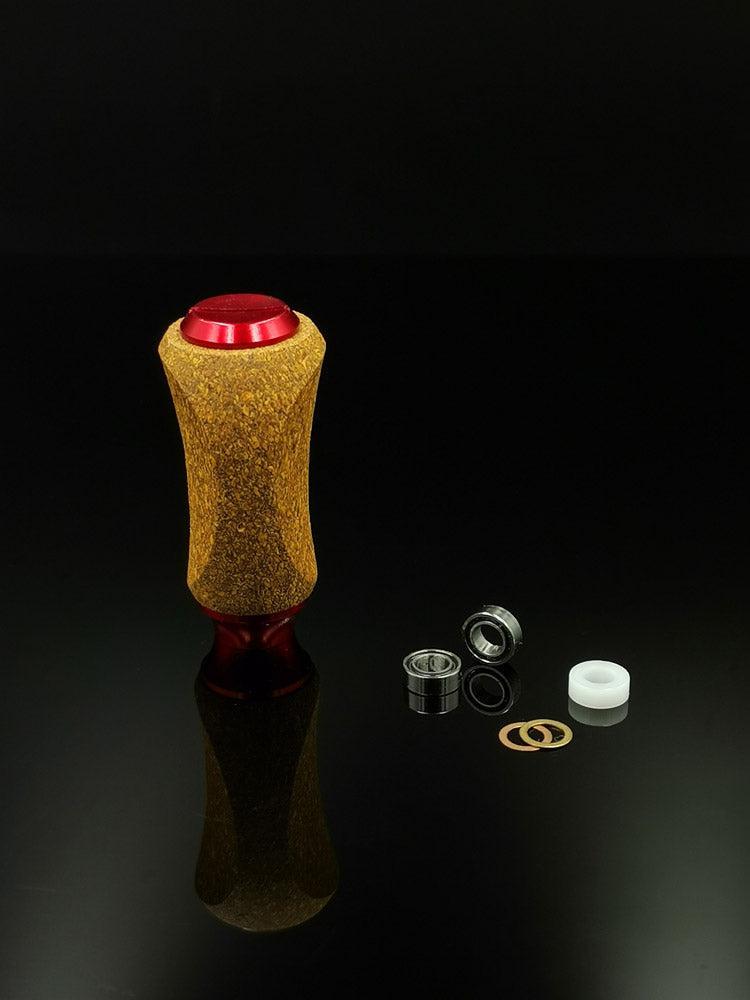 Der RL-TNG Kork Knob von RL-Angelrollentuning verfügt über einen Holzgriff mit einer roten Metallober- und -unterseite, steht aufrecht mit Metalllagern, zwei Unterlegscheiben und einem weißen Abstandshalter – ideal für die universelle Passform auf Ihrer Angelrolle.