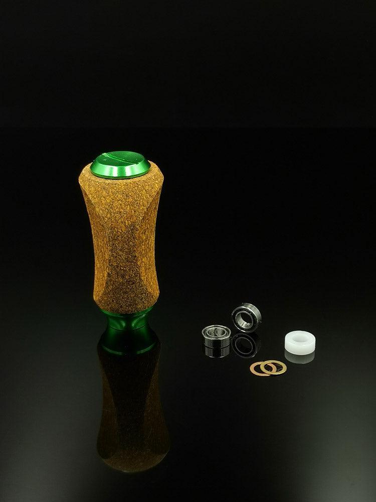 Der RL-TNG Kork Knob von RL-Angelrollentuning, ein mehrfarbiger, universell passender Griff mit Korkdetails, steht aufrecht auf einer reflektierenden schwarzen Oberfläche neben einem Lager, einer Unterlegscheibe, zwei Ringen und einem weißen Kunststoff-Abstandshalter.