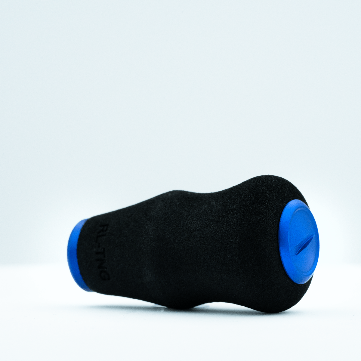 Ein schwarzer RL-TNG OCT 24 EVA-Knopf von RL-TNG mit blauen, runden Enden ruht auf weißem Untergrund. Er besteht aus weichem EVA-Material, trägt den partiellen „RLTNG“-Schriftzug und verspricht maximalen Grip bei ergonomischem Design.