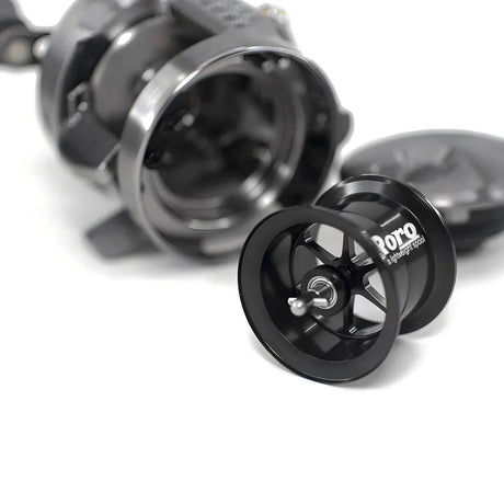 Eine Nahaufnahme einer zerlegten Roro Lure BFS Titanium Spule CQ25-MG | 23 Calcutta Conquest BFS in Schwarz, die die Hauptspule und die Innenteile auf einem weißen Hintergrund zeigt.