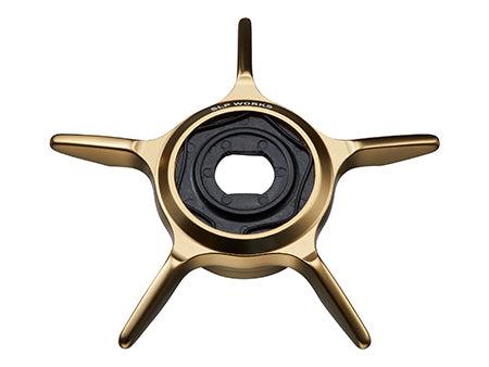 Die SLP Works 24 Steez SV TW SCL Star Drag von SLP Works ist eine goldene Zentralverschlussmutter mit einem schwarzen Innenring und einem Markenschriftzug auf der Oberseite, der an die Steez SV TW-Komponenten erinnert. Es verfügt über ein Fünf-Speichen-Design und ist auf einem weißen Hintergrund fotografiert.