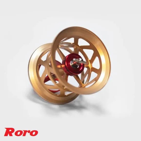 Eine goldene und rote BFS Titanium Spule X27 von Roro Lure, mit einem perforierten Design, ist auf einem weißen Hintergrund abgebildet. In der unteren linken Ecke ist in roter Schrift "Roro Lure" zu lesen.