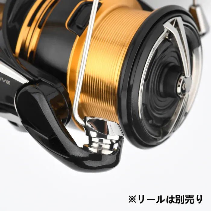 Nahaufnahme eines Gomexus Schnurlaufröllchens für Daiwa 23 Regalis in Gold und Schwarz von Gomexus, vor einem schlichten weißen Hintergrund. Der japanische Text unten rechts lautet 