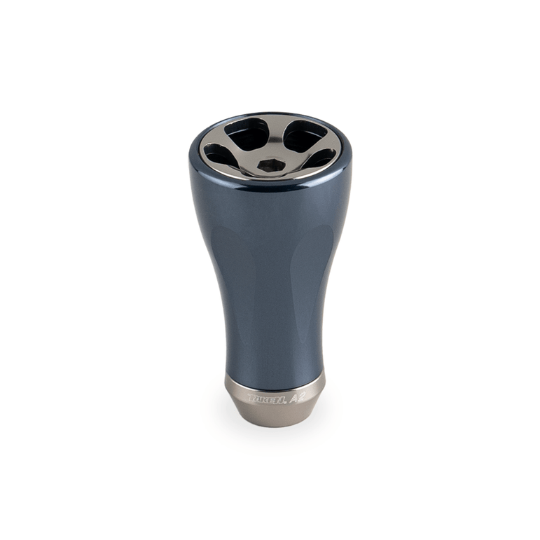 Der Taken A2 Knob 36mm ist ein metallischer Ozean Blau Aluminium Tuning Knauf für Shimano & Daiwa Angelrollen. Er verfügt über einen glatten, konischen Körper, eine glänzende, abgerundete Oberseite mit vier kreisförmigen Aussparungen und ein dezent eingraviertes Taken Logo auf der breiten Basis.