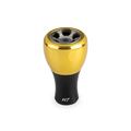 Ein Taken H7 Knopf 40mm von Taken, in Soft Gold mit schwarzem Sockel und "H7" Markierung, entwickelt für das Tuning von Shimano & Daiwa Baitcaster oder Spinnrollen, wird auf einem weißen Hintergrund gezeigt.