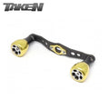Der Taken H7 SS Crossover Carbon Griff 100 mm mit weichen goldenen H7 Aluminiumknöpfen für Shimano und Daiwa Rollen zeigt das TAKEN Logo in der oberen linken Ecke auf weißem Hintergrund.