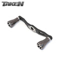 Der Taken One11 A2 Carbon Griff 111 mm in gunmetal mit zwei A2 Aluminium Knöpfen für Shimano & Daiwa ist auf weißem Hintergrund abgebildet. Das Wort TAKEN erscheint in stilisierten Buchstaben oben links.