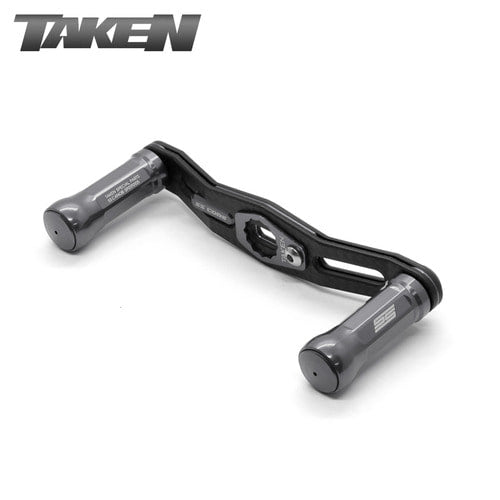 Eine gunmetalfarbene Taken SS Carbon Handle 90 mm Tuning-Doppelrahmen-Carbonkurbel mit SS-Aluminiumknöpfen für Shimano & Daiwa wird vor einem weißen Hintergrund gezeigt; die Marke Taken erscheint oben links, ideal für Fans des Finesse-Fischens.