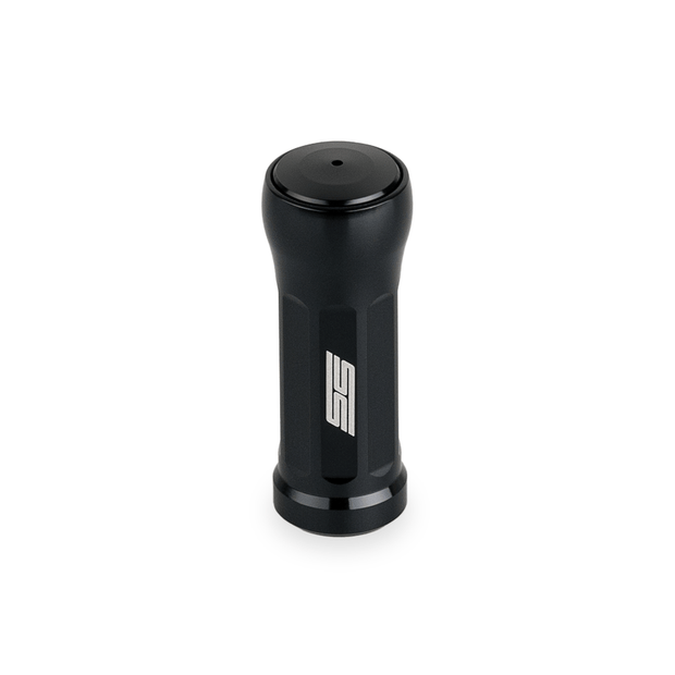 Der Taken SS Knob 35mm von Taken ist ein schwarzer, zylindrischer Aluminiumknopf mit geriffeltem Körper und "SS"-Logo, perfekt für die Aufrüstung von Shimano- und Daiwa-Angelrollen, abgebildet auf einem schlichten weißen Hintergrund.