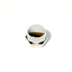 Eine Nahaufnahme der Avail Shimano Handle Locknut M7 für Original Shimano Kurbeln, in Chrom, zeigt eine Sechskantmutter mit einer weißen Kunststoffkappe, die teilweise mit dunkler Flüssigkeit gefüllt ist, vor einem schlichten weißen Hintergrund.