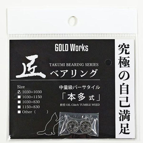 Eine schwarz-weiße Gold Works-Verpackung mit der Aufschrift "Gold Works Takumi Kugellager 1150 x 830" enthält zwei Takumi-Kugellager in einem durchsichtigen Beutel, mit japanischem Text, Größenangaben und "Angelrolle" auf der Verpackung.