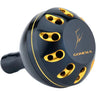 Der Gomexus Aluminium Reel Power Knob 45-47 mm Typ B in blau und gold hat ein rundes Design, mehrere Löcher und das eingravierte Logo auf der Oberseite - gefertigt aus Aluminium von Gomexus.