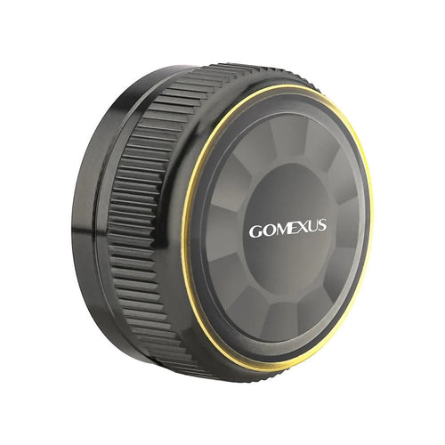 Auf weißem Hintergrund ist eine schwarze, runde Gomexus Aluminium-Spulenspannungsknopfkappe für 20/22/23 Metanium aus einer Aluminiumlegierung mit strukturiertem Griff und dünnem gelben Akzentring abgebildet.