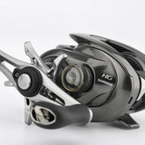 Die Nahaufnahme einer Shimano-Baitcaster-Rolle zeigt die Gomexus Aluminum Spool Tension Knob Cap für 20, 22, 23 Metanium, mit Markendetails auf einem metallischen und schwarzen Gehäuse vor einem schlichten weißen Hintergrund.