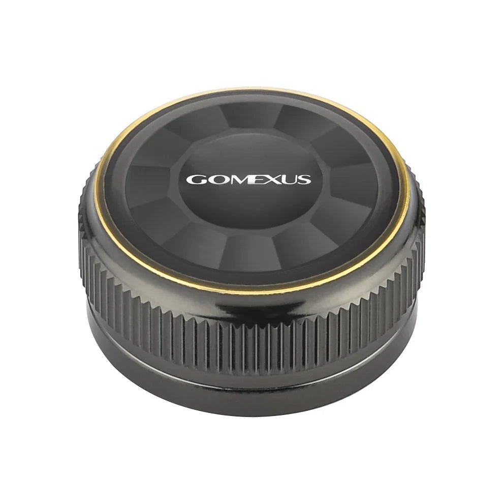 Die Gomexus Aluminum Spool Tension Knob Cap für 20, 22 und 23 Metanium Shimano Baitcaster ist rund und schwarz mit einem Metallic-Finish, geriffelten Seiten für mehr Griffigkeit, einem goldenen Ring am Rand und dem Aufdruck 