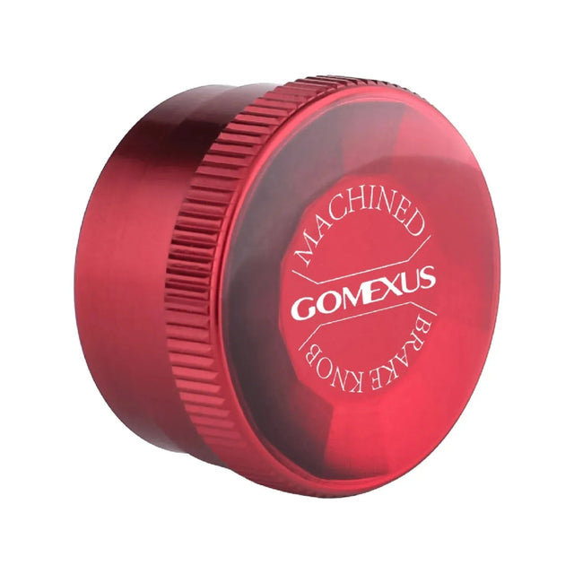Eine rote, zylindrische Gomexus-Aluminium-Spulenspannungsknopfkappe mit strukturiertem Griff für Daiwa-, Tatula- und Salamandura-Rollen; auf der Oberseite ist in Weiß „MACHINED BRAKE KNOB GOMEXUS“ aufgedruckt.