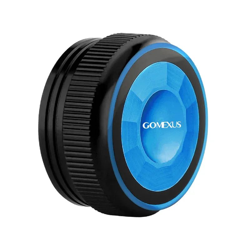 Eine Nahaufnahme der Gomexus Aluminium-Spulenspannungsknopfkappe für Shimano WT4- und SLX DC-Baitcaster, die ihr kreisförmiges schwarzes Design mit strukturiertem Griff und glatter, blauer, facettierter Mitte zeigt.