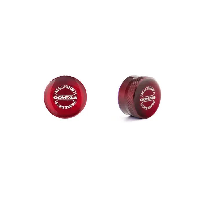 Auf weißem Hintergrund sind zwei rote, runde Gomexus-Aluminium-Spulenspannungsknopfkappen abgebildet: Auf der einen sind oben „MACHINED“ und „COMEDUS“ zu sehen, während auf der anderen die Dicke und die strukturierte Seite hervorgehoben sind.