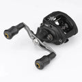 Eine schwarze Baitcasting-Angelrolle mit zwei Gomexus Carbon Forged F24-Knöpfen, sichtbarer Spule, Einstellknöpfen und aufgedruckten Markierungen befindet sich auf einem weißen Hintergrund.
