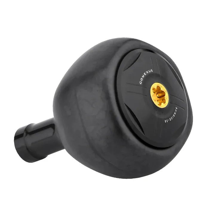 Vor einem weißen Hintergrund ist ein 38-mm-Angelrollen-Kurbelknopf Gomexus FA38S Carbon Knob in Schwarz mit goldener Mitte aus TORAY-Kohlefaser für Stabilität und ergonomisches Design abgebildet.