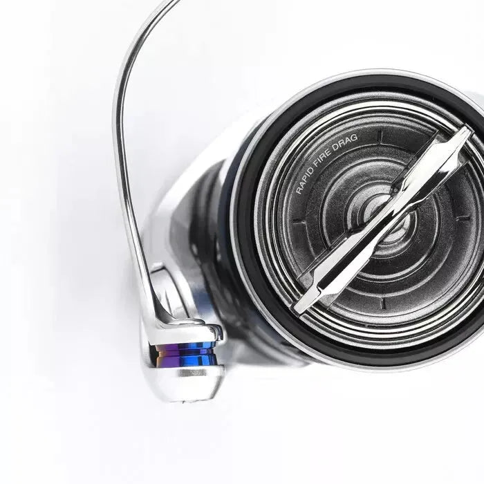 Eine Nahaufnahme eines metallischen Gomexus Schnurlaufröllchens für Shimano-Rollen auf weißem Hintergrund, mit RAPID FIRE DRAG in der Nähe des Griffs und einer leichtgängigen Titan-Linienrolle für verbesserte Leistung.