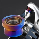 Eine Nahaufnahme des Gomexus Schnurlaufröllchens für Shimano SW Angelrollen von Gomexus mit einem Titan-Finish mit Farbverlauf in Blau-, Lila- und Goldtönen auf dunklem Hintergrund.