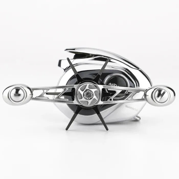 Nahaufnahme der Gomexus Sternbremse 60 mm auf einer Shimano Antares 19 Rolle. Sie besticht durch ihr glänzendes Silber-Finish mit schwarzen Akzenten. Der horizontale Griff hebt die sternförmige Gomexus Sternbremse von Gomexus hervor, die vor einem schlichten weißen Hintergrund zu sehen ist.