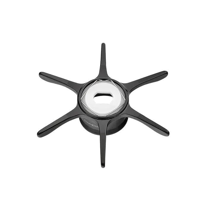 Ein schwarzes sechsbeiniges Objekt mit einem kreisförmigen Zentrum und einer sechseckigen Öffnung aus Metall, das als Gomexus Sternbremse 60 mm von Gomexus (Schwarz) identifiziert wird, wird auf einem weißen Hintergrund fotografiert.