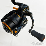 Eine Nahaufnahme einer Hedgehog Studio Extra Super Duralumin Schraube für Schnurlaufröllchen, einer Angelrollenschraube von Hedgehog Studio, ist mit Kurbelgriffdetail vor weißem Hintergrund zu sehen. Das HEDGEHOG STUDIO-Logo erscheint unten rechts.