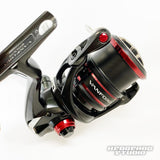 Nahaufnahme einer schwarz-roten Spinnrolle mit der Hedgehog Studio Extra Super Duralumin Schraube für Schnurlaufröllchen. Detaillierte Metallteile und das Hedgehog Studio-Logo sind in der unteren rechten Ecke sichtbar.