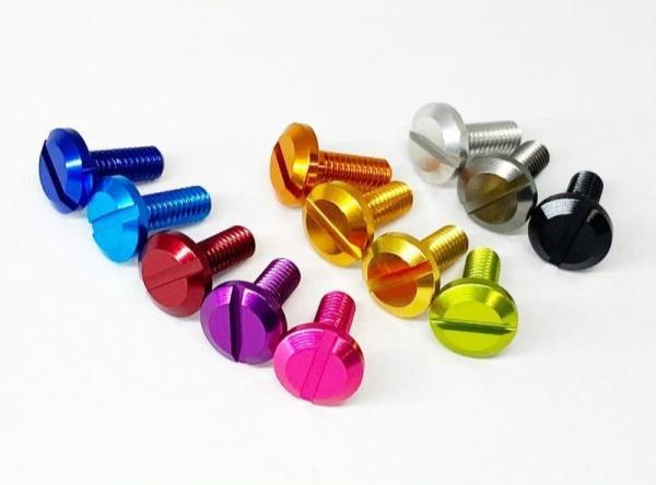 Ein Set mit zehn Hedgehog Studio Extra Super Duralumin Schraube für Schnurlaufröllchen in leuchtendem Blau, Rot, Gelb, Gold, Silber, Schwarz, Lila und Pink von Hedgehog Studio, präsentiert auf einer weißen Oberfläche.