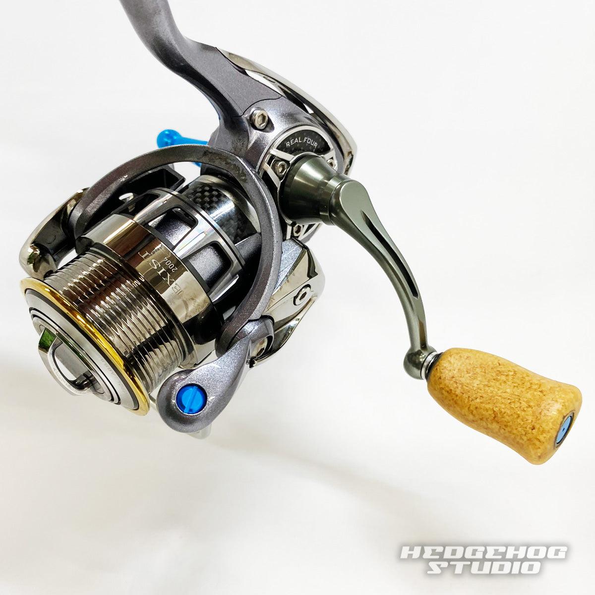 Nahaufnahme der Hedgehog Studio Extra Super Duralumin Schraube für Schnurlaufröllchen mit detaillierten mechanischen Teilen und metallischem Finish; das Hedgehog Studio-Logo erscheint unten rechts auf weißem Hintergrund.