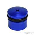 Eine kleine, zylindrische, blaue Duralumin-Knopfkappe von Hedgehog Studio für Daiwa Zaion mit einem Loch oben, einem schwarzen O-Ring in der Mitte und dem Wasserzeichen von Hedgehog Studio unten rechts. Passend für Angelrollen-Zubehör.